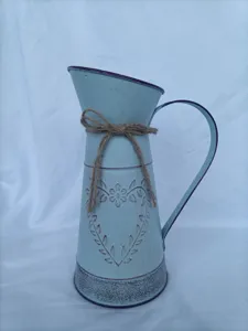 Λεπτομέρεια vintage γαλάζιου σιδερένιου βάζου με ανάγλυφη καρδιά και διακοσμητικό φιόγκο