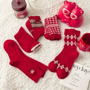 Nahaufnahme von roten Retro-Baumwollsocken mit Rautenmuster und filigranen Spitzen.