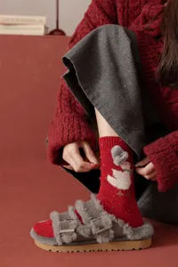Close-up of cozy red wool blend socks featuring cute duck knit hat detail, warm winter style.