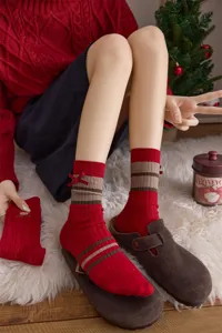 Retro-Socken mit rot-braunen Streifen und süßer kleiner Schleife für Damen im Herbst.
