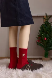 Nahaufnahme Detail festlicher roter Baumwollsocken mit süßer kleiner Bärenstickerei.