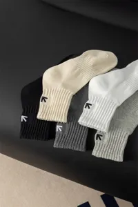 Primo piano dettagliato di calze sportive da uomo in cotone con motivo a freccia ricamata.