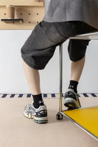 Calze da uomo a tubo medio nero in cotone con ricamo freccia bianca, stile streetwear casual.