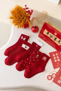 Red New Year mid-calf socks with cute bow embroidery and bear design for festive wear.