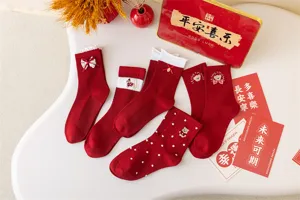 Detailed close-up of festive red mid-calf socks featuring cute bear embroidery and bows for New Year.