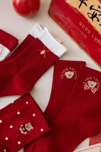 Red festival mid-tube socks with cute bear embroidery, white cuffs and bow detail.