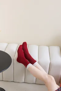 Detailed shot of red mid-calf socks featuring cute bow embroidery and contrast white cuffs.