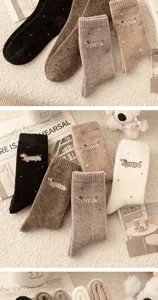 Primer plano de calcetines de invierno suaves y cálidos con bordado de perro y tejido polar.