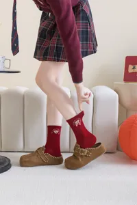 Red mid-tube socks for women featuring cute bow embroidery and festive New Year celebration style.