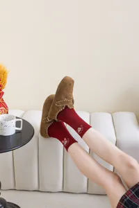 Cozy detail shot of red bow bear embroidered socks paired with stylish brown suede shoes.