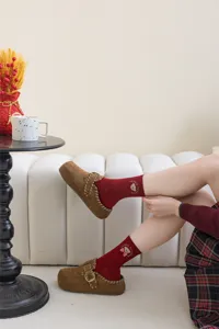 Cozy red mid-calf socks featuring cute embroidered bear and bow design, perfect for festive winter wear.