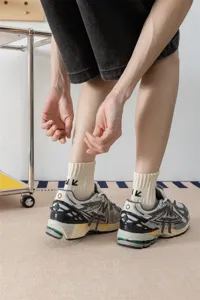 Vista dettagliata di calzini a tubo medio in cotone casual abbinati a scarpe da ginnastica retrò