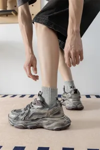 Calze sportive da uomo con design a freccia ricamata, abbinate a sneaker chunky vintage.
