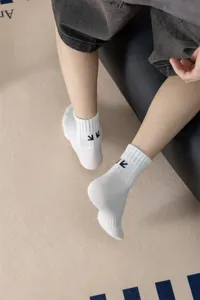 Calzini sportivi da uomo in cotone pettinato bianco con eleganti frecce ricamate nere.