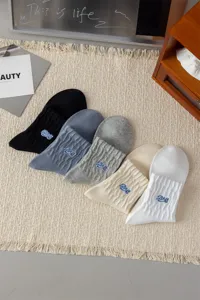Men's mid-tube cotton socks featuring trendy embroidery, comfy casual wear in multiple colors.
