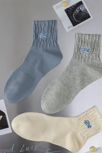 Men's mid-tube cotton socks featuring stylish letter embroidery and breathable ribbed cuffs.