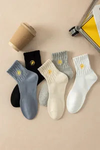 Detail shot of cotton crew socks featuring embroidered yellow lightning bolts and stylish ribbed cuffs.