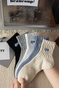 Detailed view of men's cotton mid-tube socks in five colors with blue letter embroidery.
