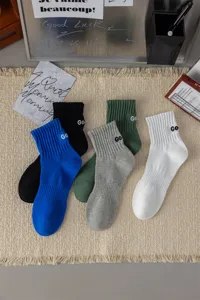 Detailed view of casual mid-calf socks featuring comfortable cotton and embroidered letter details.