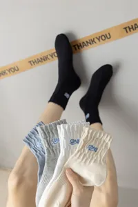 Comfortable cotton mid-calf socks for men and women, featuring stylish letter embroidery.