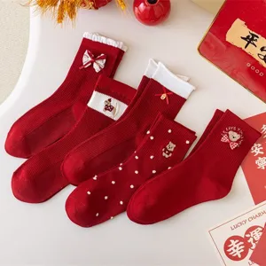 Red festive socks for women with cute bear embroidery and bows, perfect for New Year wear.