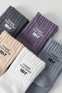 Detailed shot of multi-color ribbed mid-calf cotton socks with cuff text, Japanese camp style.