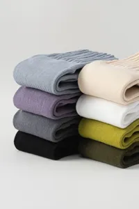Detailed close-up view of stacked men's thick knit cotton socks in assorted autumn colors.