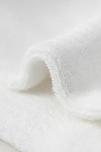 Close-up detail of thick white loop knit fabric texture, showcasing soft and comfortable material.