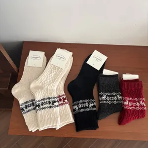 Detailed shot of winter warm knit wool socks featuring classic snowflake and elk holiday patterns.