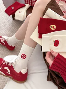 Nahaufnahme von festlichen chinesischen Neujahrs bestickten Baumwollsocken in Rot und Weiß.