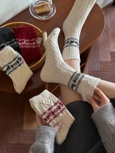 Cozy winter wool socks with Nordic Christmas reindeer and snowflake patterns for women.