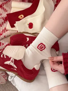 Gemütliche rote und beigefarbene Baumwollsocken mit Stickerei, ideal für die festliche Jahreszeit.