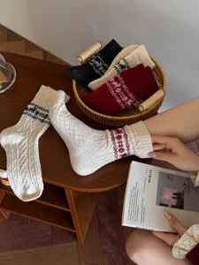 Cozy knitted winter socks featuring festive snowflake and cute reindeer holiday patterns.