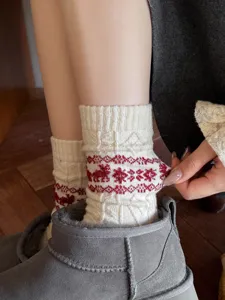 Close-up detail shot of winter retro Christmas style warm wool slouchy socks with nordic elk pattern.