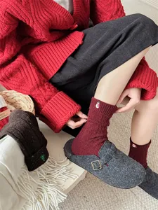 Close-up detail of cozy winter wool socks featuring cute snowman embroidery and soft ribbed cuff.