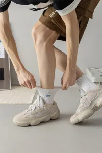 Detailed view of men cotton mid-tube socks in white with stylish blue embroidery accent.