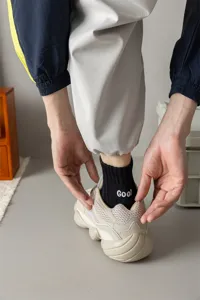 Men's mid-calf athletic socks with heel letter embroidery, comfortable combed cotton fabric.