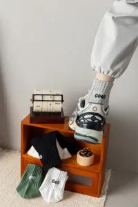 Detailed shot of men's cotton crew socks with heel letter embroidery, casual sports style.