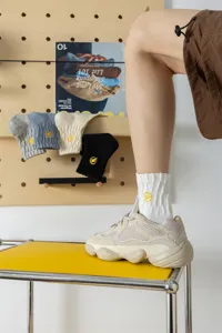 Men's cotton mid-tube socks featuring yellow lightning embroidery, paired with trendy sneakers.