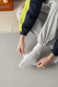 Men's white ribbed mid-calf socks detail, showing great elasticity and breathable cotton fabric.