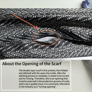 Vue detaillee d'un foulard en soie satinee double couche avec motif noir et blanc et couture.