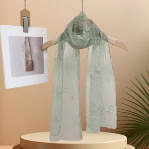 Vue détaillée d'un foulard en dentelle brodée vert clair pour femme, design élégant floral.