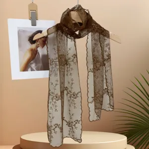 Gros plan de la texture de l'écharpe en dentelle florale marron, artisanat exquis et style rétro.