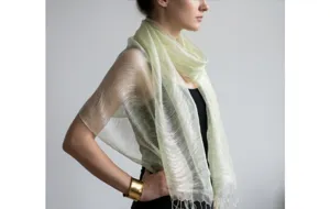 Detailed closeup of the elegant light green sheer silk scarf featuring delicate fringe trim.