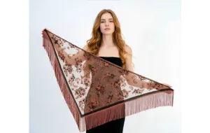 Vista dettagliata delle eleganti frange e del motivo jacquard floreale sullo scialle.