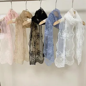 Vue détaillée d'écharpe en dentelle florale suspendue, accessoire en tulle délicat.