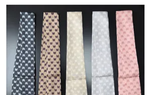 Detail view of narrow silk skinny scarves with elegant heart diamond print patterns in multi colors.