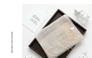 Detailed view of the luxury silk blend sheer scarf with delicate hand-knotted fringe.