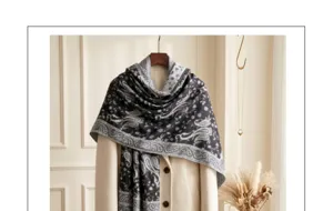 Detailed view of a stylish black and grey paisley jacquard scarf draped over a coat.
