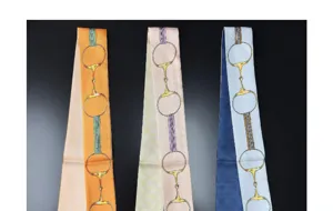 Detailed view of women's narrow silk twilly scarves with elegant equestrian bit patterns.